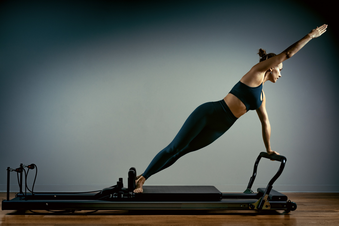Woman doing core work on Pilates reformer machine