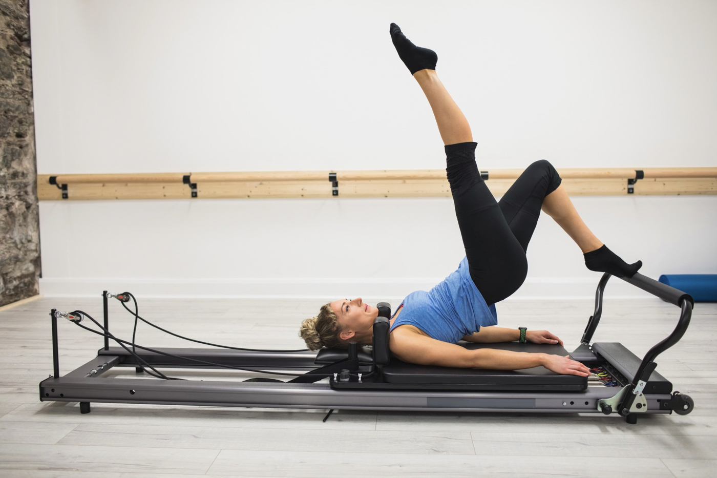 Woman performing Pilates reformer leg exercise