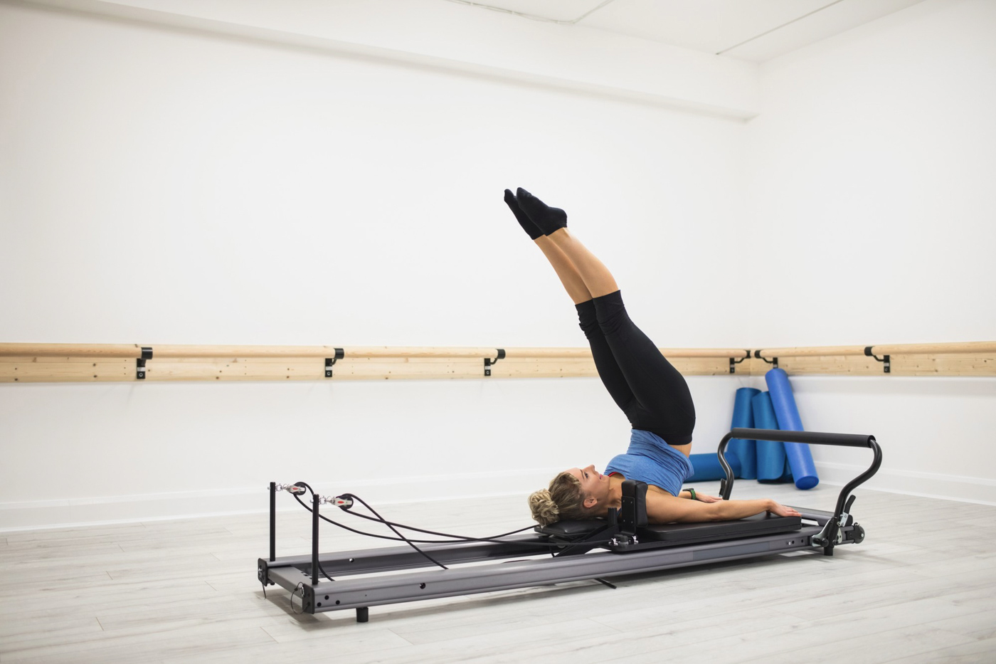 Reformer Pilates leg lift in bright studio